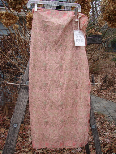 Magnolia Pearl NWT European Cotton MP Block Print Scarf Rosette features a flowing, slightly sheer fabric with a continuous floral pattern, accented by a contrasting border, hanging elegantly outdoors.