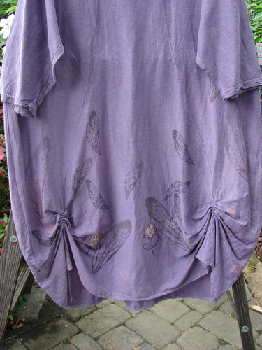 Barclay Hemp Cotton Silk Voile Belle Dress Wing Violet Size 2: A purple dress with butterfly and flower patterns, featuring a shallow neckline, pleated back, dropped shoulders, and a unique bell shape.