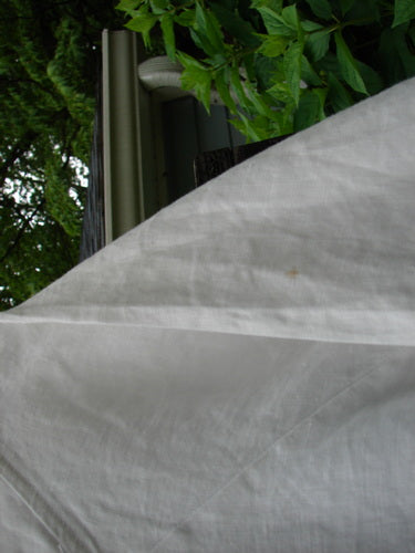 A Barclay Linen Vertical Seam Pocket Dress Leaf Dove White Size 2, displayed on a hanger, showcasing its rounded neckline, wide short sleeves, swaying lower hemline, and exterior front pocket.