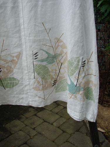 Barclay Linen Vertical Seam Pocket Dress Leaf Dove White Size 2, featuring a rounded neckline, wide short sleeves, and a front pocket, with bird and leaf designs on medium-weight linen.