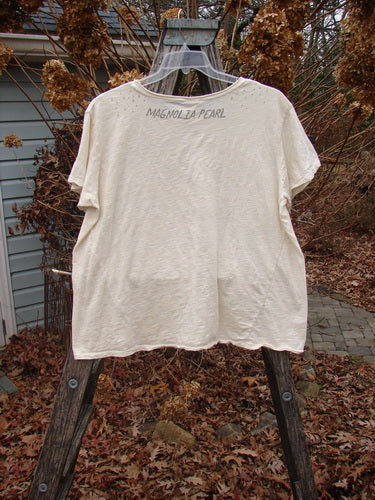 Magnolia Pearl NWT Cotton Jersey Boyfriend Tee Ganesh Moonlight OSFA displayed on a wooden ladder outdoors. Features rolled edges, A-line shape, and MAGNOLIA PEARL print on the upper back.