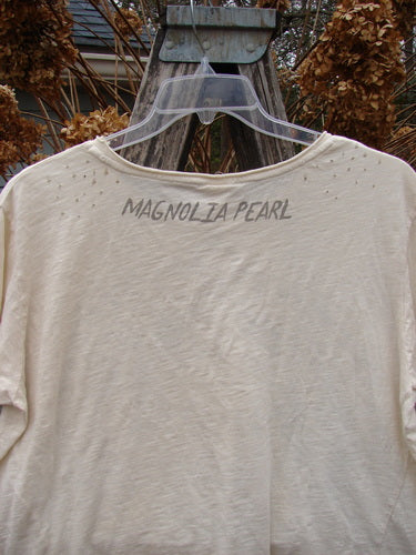 Magnolia Pearl NWT Cotton Jersey Boyfriend Tee Ganesh Moonlight OSFA on hanger, showcasing light-cream distressed design, rolled edges, and unique diagonal seam, embodying a creative, vintage-inspired aesthetic.