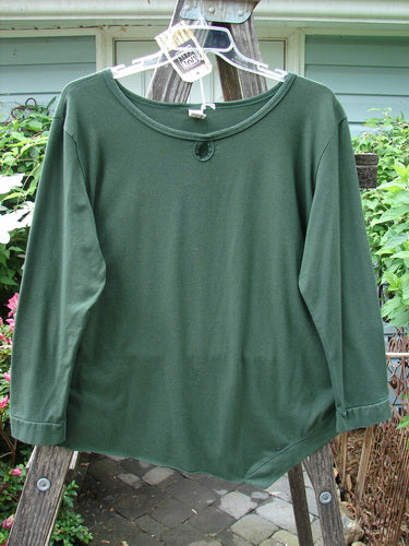 A Barclay NWT Cotton Lycra Keyhole Pullover Top in Rich Clover, displayed on a clothes rack, showcasing its long sleeves, angled hem, and keyhole neckline. Size 1, in perfect condition.