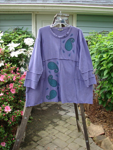 Barclay Hemp Cotton Dual Quadrant Dress Paisley Power Royal Size 2 displayed on a hanger, featuring double quadrant exterior seams, varying hemline, and two front drop exterior pockets.