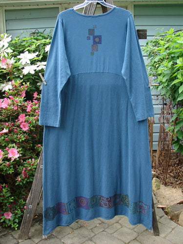 Alt text: Barclay Hemp Cotton Curved A Line Dress Elements Tealen Blue Size 2, displayed on a clothes rack, showcasing its extra-long length, wide A-line shape, and longer cozy sleeves.