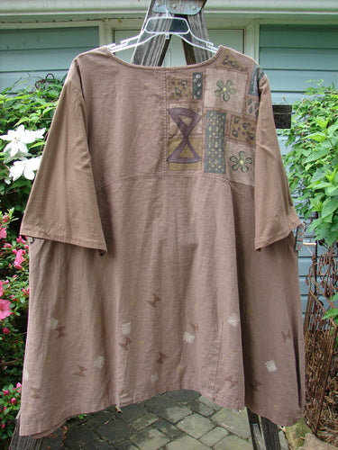 Barclay Cotton Sleeve Hemp Linen Sectional Dress Cobblestone Corner Mandorla Altered Size 2 displayed on a hanger, showcasing its patchwork design, three-quarter sleeves, and curved empire waist.