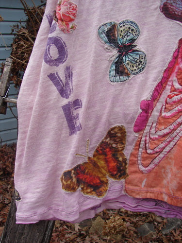 Magnolia Pearl NWT Applique Cotton Jersey Boyfriend Tee Love Is The Only Way Allium OSFA, featuring colorful butterfly and rose appliques, draped outdoors, showcasing its soft, drapey feel and unique design elements.