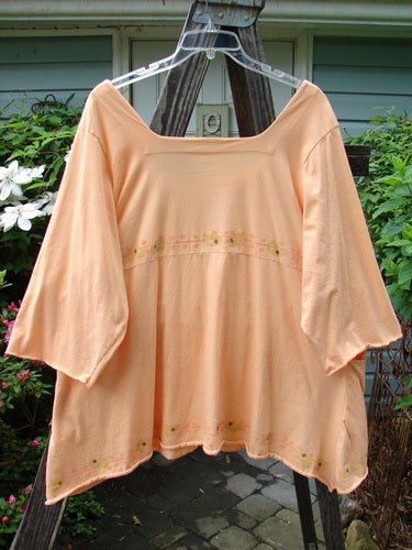Barclay Be There Top featuring Pinwheel Power design in Pastel Tangerine, Size 2. Organic cotton, empire waist, wide pleats, and a forever skirt flair. Vintage Blue Fish Clothing by Jennifer Barclay.