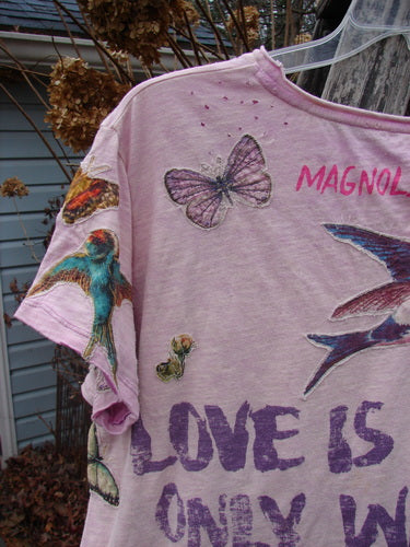 Magnolia Pearl NWT Applique Cotton Jersey Boyfriend Tee features colorful butterfly and bird illustrations, text highlights MAGNOLIA and LOVE IS ONLY, showcasing a drapey, soft cotton design with unique seams and distressing.