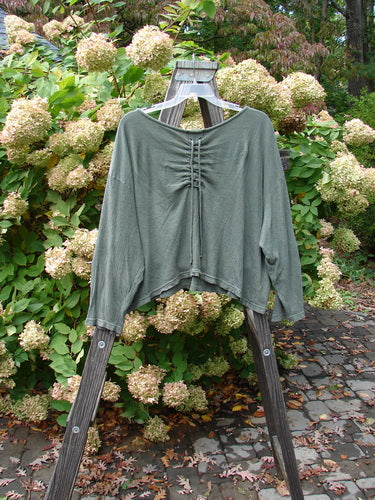 2000 Limited Edition Gauze Ruched Back Top Unpainted Green Lake Size 2: A green shirt on a wooden ladder, featuring a rounded neckline, drop shoulder, and rear center drawcord.