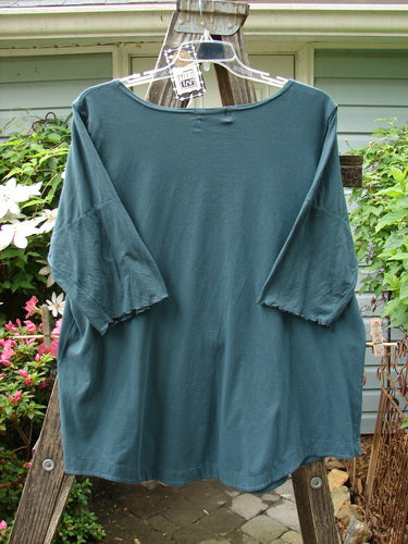 A green Barclay NWT Cotton Lycra Twinkle Top Unpainted Tealen Mineral Size 2 on a hanger with a rounded banded hemline and scooped neckline, featuring curly edgings on short sleeves.