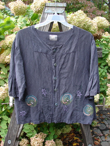 2000 Hemp Viscose Rodeo Top Space Orbit Size 1: Fitted black shirt with a blue space-themed design, pleated sleeves, and textured buttons.