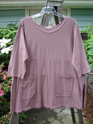 Barclay Empire Vented Pocket Top Unpainted Dusty Plum Size 2 displayed on a hanger, highlighting its rounded neckline, exterior drop pockets, and three-quarter sleeves in organic cotton.