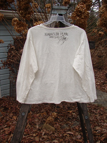 Magnolia Pearl Cotton Jersey Long Sleeved Boyfriend True OSFA drapes on a plastic hanger, showcasing MAGNOLIA PEARL and LIVE YOUR DREAM print, with rolled edges and shoulder distressing.