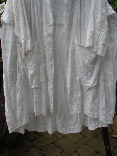 Barclay Brocade Open Front Pocket Dress Duster in white, hanging on a clothesline. Features include drop exterior pockets, varying hemline, and three-quarter length sleeves. Size 2, from Holiday Collection.