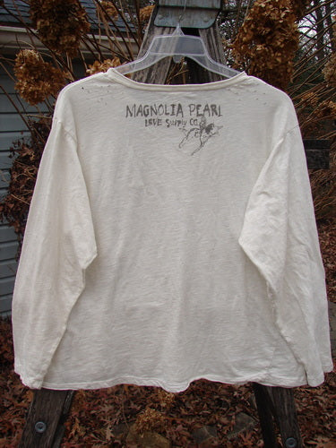 Magnolia Pearl Cotton Jersey Long Sleeved Boyfriend True OSFA features a faded MAGNOLIA PEARL LOVE Supply Co. graphic on the back, showcasing a drapey fit with rolled edges and upper shoulder distressing.