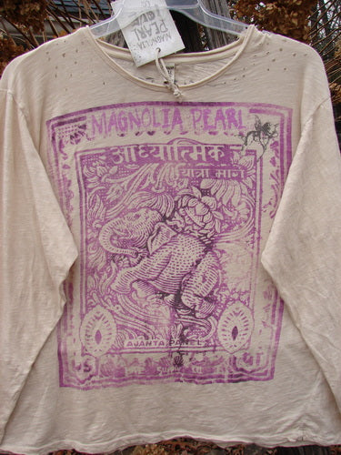 Magnolia Pearl NWT Cotton Jersey Boyfriend Tee Spiritual Walk Carousel OSFA, features purple block-print design with an elephant motif, distressed edges, and intentional holes near neckline, hanging outdoors on a plastic hanger.