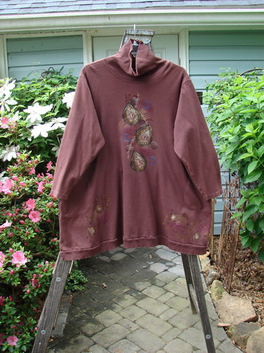 Barclay Interlock Turtleneck Pullover Tunic Top Celtic Paisley Sepia Size 2 displayed on a hanger, showcasing ribbed turtleneck, A-line shape, and side entry front pockets.