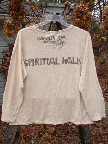 Magnolia Pearl NWT Cotton Jersey Boyfriend Tee Spiritual Walk Carousel OSFA, displayed on a hanger, features a distressed look with rolled edges, upper shoulder distressing, and a Spiritual Walk theme on the back.