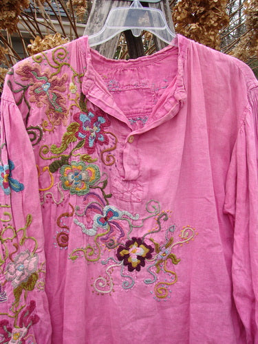 Magnolia Pearl Embroidered Linen Gypsy Johnny & Co Shirt Pinkster OSFA, featuring vibrant floral embroidery, a relaxed fit, billowy sleeves, and unique design elements like a criss-cross patched tab below the neckline.