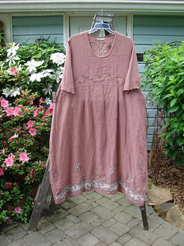 Alt Text: Barclay Linen Cotton Sleeve Banded Hem Pleat Dress Bird Gal Dusty Mauve Size 2 on a rack, showcasing its rounded neckline, empire waist seams, and vertical pleats.