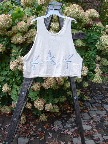1999 Pinwheel Vest Love Dove Dust Size 2: A white shirt on a wooden stand with birds on it. Perfect condition. Organic cotton. Porcelain painted buttons. Flared hemline. Length: 23 inches. Bust: 50. Waist: 50. Hips: 52. Hem circumference: 52. Blue Fish Patch.