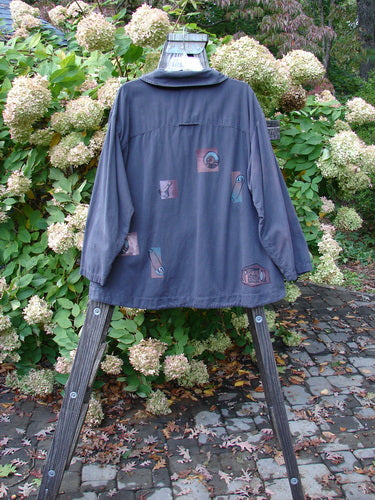 Image alt text: "2001 P3 Top Junk Drawer Licorice Size 1: A jacket on a stand with blue shirt, pictures, and wooden legs. Outdoor plant and tree vibes."