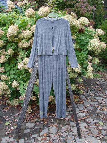 2000 Rayon Lycra Stripe Duo Cliffshadow Stripe Size 2: Grey striped outfit on a ladder, featuring a single button closure and a contrasting straight cropped back line. Perfect for layering, this lightweight and flowy topper is made from a lovely rayon lycra blend. The matching straight pant has a full elastic waistband and a bottom flare with soft blending paint. A stylish and slimming look, this duo is a must-have from the Fall Collection.