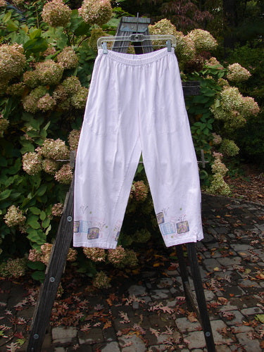 A pair of Barclay Simple Vent Pants in Pale Pink, size 0, made from organic mid-weight cotton. Features include a full elastic waistline, side entry front pockets, and sweet painted flowers in a garden theme. The pants have tiny lower vents and measure Waist Relaxed 26, Waist Extended 36, Hips 50, Inseam 24, and length 39 inches.