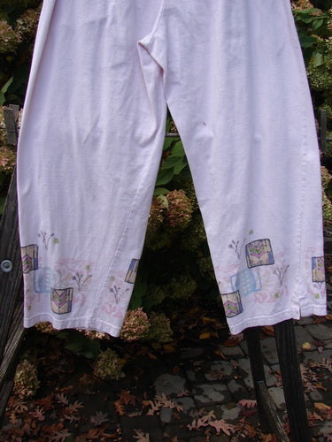 Image alt text: Barclay Simple Vent Pant Garden Pale Pink Size 0 - A pair of pants with sweet painted garden-themed designs and tiny lower vents.
