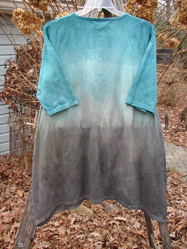 Barclay NWT Wander Tunic Tee Contour Daisy Logo Bolsena Size 0, showcasing a dip-dyed teal to charcoal gradient, with three-quarter sleeves and a rounded neckline on a clear hanger outdoors.