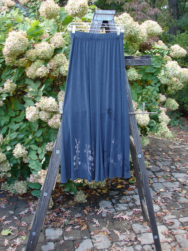 1998 Rayon Lycra Tendril Mayflower Duo Onyx Size 1: A blue skirt with botanical theme paint on a wooden easel.