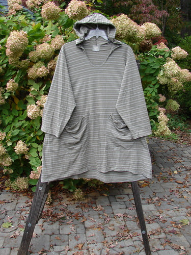 2000 Resort Hooded Pocket Pullover, black olive grey stripe, size 2, on wooden stand. A-line shape, oversized hood, elastic-topped pockets, zigzag theme paint lower sleeve.