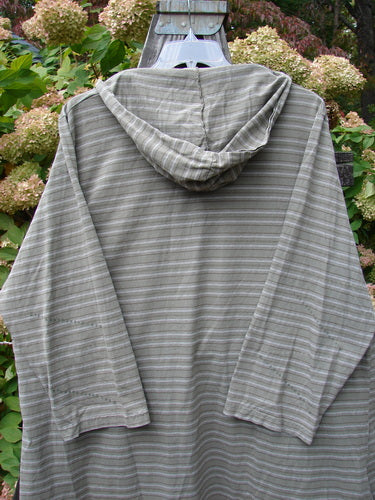 2000 Resort Hooded Pocket Pullover with Zig Zag pattern, size 2: A person wearing a grey striped hoodie with a flowing oversized hood and elastic-topped pockets.