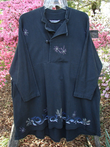 1997 Rhadha Dress Star Flowers Trail Obsidian Size 2, featuring an asymmetrical placket with toggle buttons, stylized floral motifs, mock mandarin neckline, and a rounded swingy hemline, displayed against flowering shrubs.