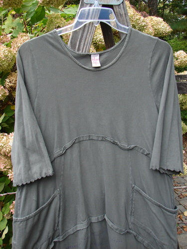 Barclay Cotton Lycra Raw Edge Vector Pocket Tunic, size 1, on wooden pole, with flutter accents and wrap side pockets.