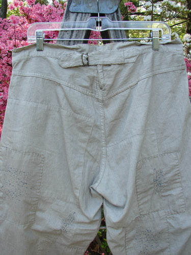 Magnolia Pearl NWT European Denim Lilou Trouser Natural Pinstripe OSFA hanging, showcasing adjustable belt tab, patch pockets, and distinctive stitchery, embodying vintage-inspired creativity from Bluefishfinder.com.