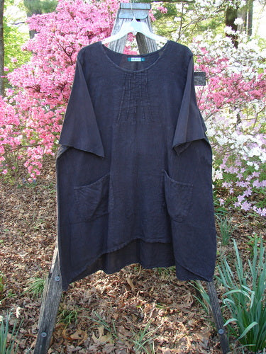 Barclay Linen Cotton Sleeve Milkmaid Dress Unpainted Black Noir Size 2, featuring a loose fit, short sleeves, sunrise pleats, empire waist, diagonal pockets, displayed on a hanger against a floral backdrop.