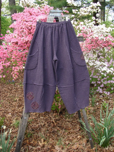 Barclay Patched Crepe Sectional Pocket 4 Square Pant Diamond Brum Size 1 displayed outdoors, highlighting its elastic waistband, patchwork detail, and unique wide-leg silhouette, draping into a 3D diamond shape.