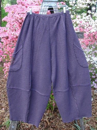 Barclay Patched Crepe Sectional Pocket 4 Square Pant Diamond Brum Size 1 displayed against pink flowering shrubs, featuring a unique 3D diamond cut from the knee down and generous wrap-around hip pockets.