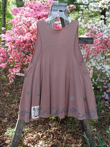 1993 Short Column Vest Floral Vine Rosewood OSFA, displayed on a wooden ladder, showcases a swingy silhouette with floral vine design, decorative hem prints, and a vintage clay button, set in a garden backdrop.