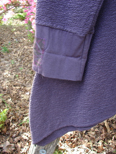 Barclay Patched Crepe Cross Over Tunic Top Diamond Brum Size 1, featuring textured cotton crepe with a crossover neckline, uneven hem, and visible sleeve cuff, hanging outdoors against a wooden post.