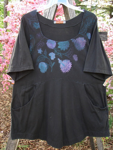 Barclay Short Sleeved Be There Top Floral Bud Black Size 1 features elbow-length sleeves, a scooped neckline, and purple/blue floral print. It includes hip-level pockets and a curved empire waist seam.