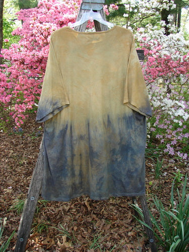 Barclay Art Tunic Tee Mottled Sun Field and Night OSFA draped on a wooden A-frame, showcasing its light-to-dark gradient, outdoors amidst blooming bushes.