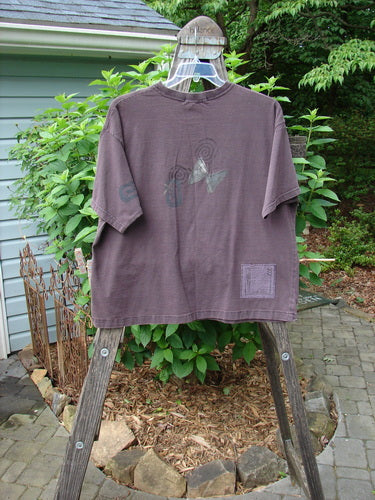Vintage 1995 Short Sleeved Tee Butterfly Madderlake Altered Size 2 on a hanger. Organic cotton tee with ribbed neckline, drop shoulders, and atom paint details. Reflects Blue FishFinder's creative vintage clothing ethos.