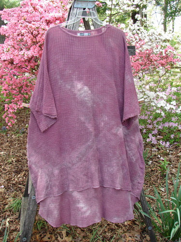 Barclay Crinkle Gauze Ana Tunic Dress Unpainted Mottled Rusty Rose OSFA displayed on a wooden ladder, showcasing its loose fit, waffle-knit texture, wide sleeves, and relaxed hem amidst a natural backdrop.