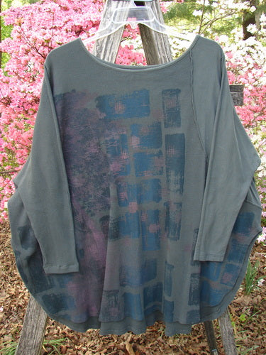Barclay Thermal Monte Verde Vented Tunic Night Black Army OSFA: A slate-gray, long-sleeved tunic with abstract blue and purple patterns, featuring side vents and exterior stitchery, hanging outside.
