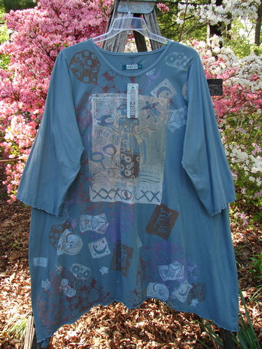 Barclay NWT Color Wheel Tunic Bird Gal Delaware Size 2, featuring a loose fit, round neckline, and three-quarter sleeves, with abstract motifs on soft blue organic cotton, hanging on a trellis.