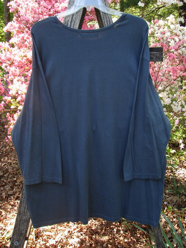 Barclay Long Sleeved Studio Tee Metallic Love Dove Steel Grey OSFA, displayed on a hanger outdoors against pink flowers, showcasing its wide, boxy shape, long sleeves, and rounded, rolled neckline.