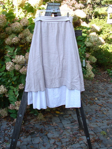 Barclay Linen Fold Over Two Tier Skirt, Daisy Mallow. Organic linen skirt with fold-over cotton panel waistline. Full paneled waistline, fluttery upper layer, and painted daisy theme on lower border. Size 1.